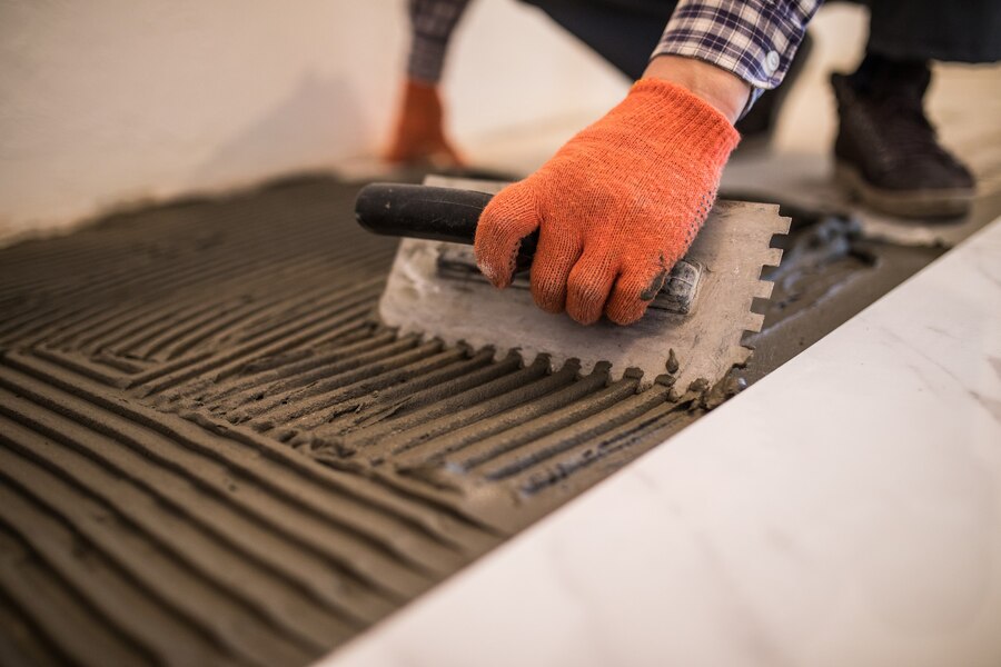 laying-ceramic-tiles-troweling-mortar-onto-concrete-floor-preparation-laying-white-floor-tile_231208-6790